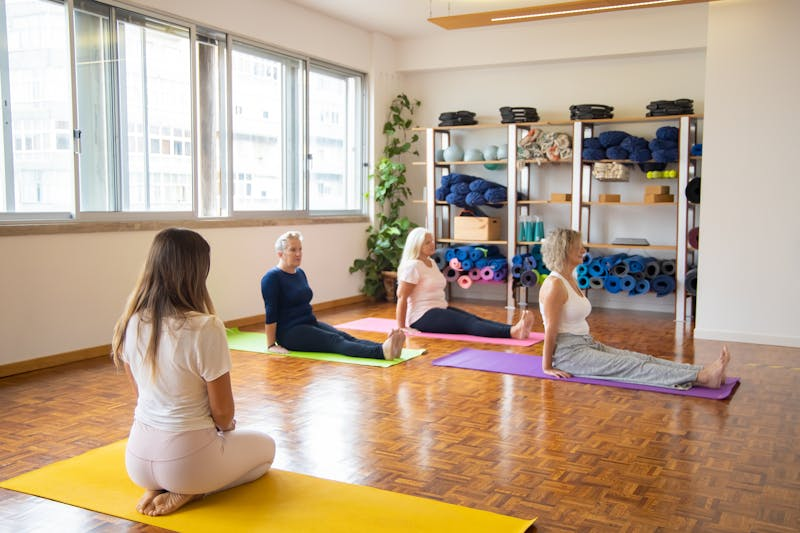 a group of older women stretching in a yoga studio
