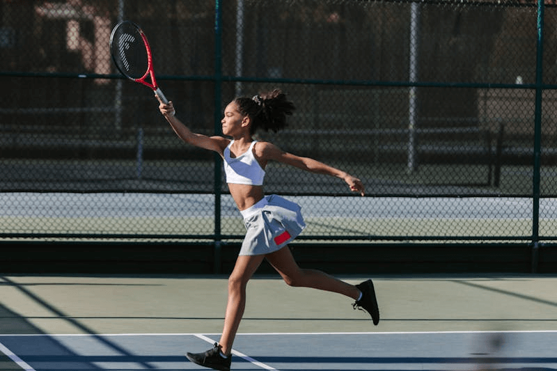 a young girl playing tennis