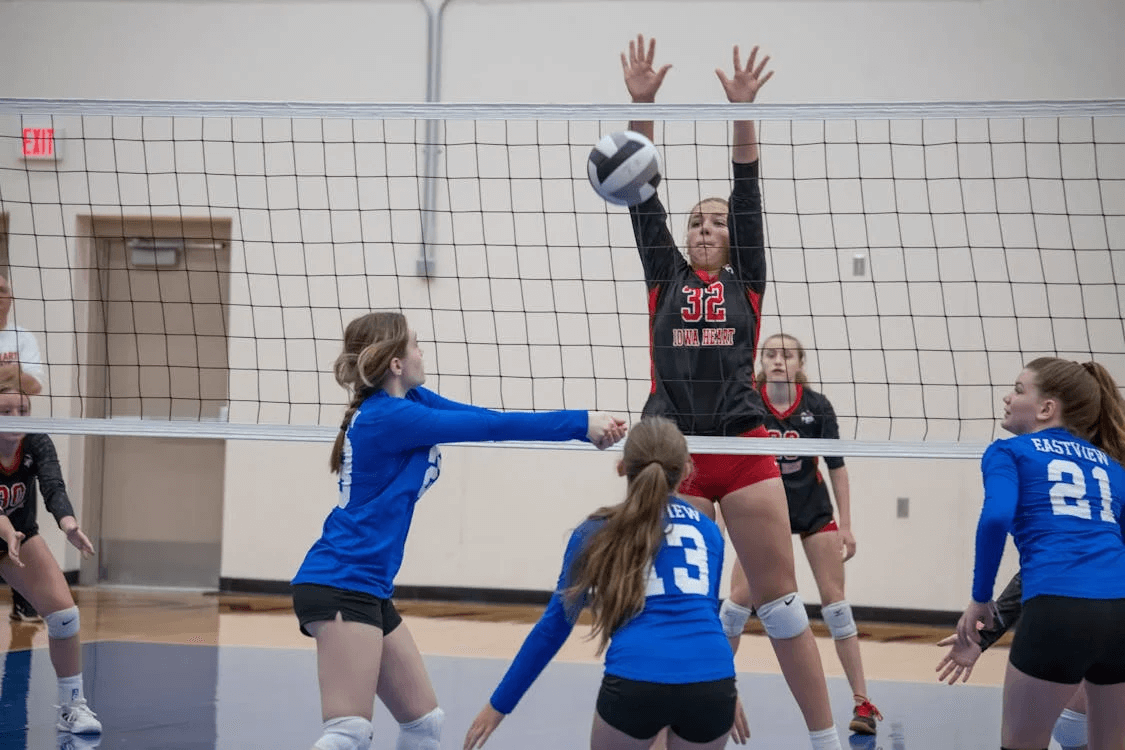 female volleyball players playing a game inside a gym