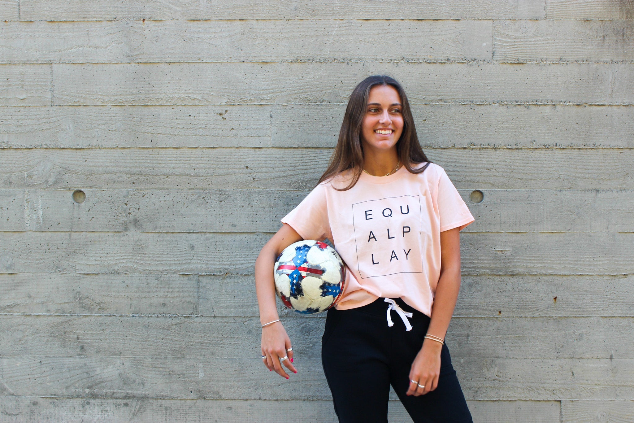 A model poses in an Equal Play athletic graphic tee by Goal Five.