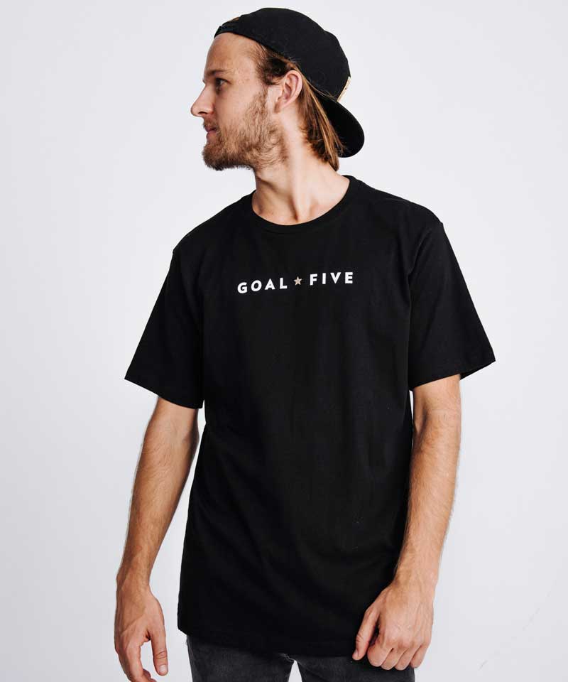 The model poses wearing the Goal Five black cotton T shirt for men.