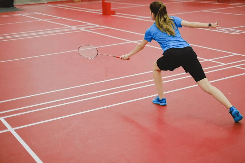 a female athlete playing the sport of badminton