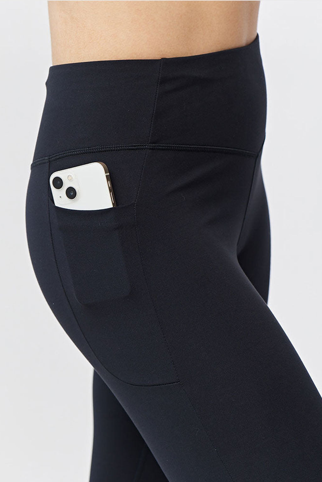 Model wearing Go Again Women's Cropped Leggings Length 21" in black, featuring squat-proof fabric and a smartphone partially visible in the convenient side pocket.
