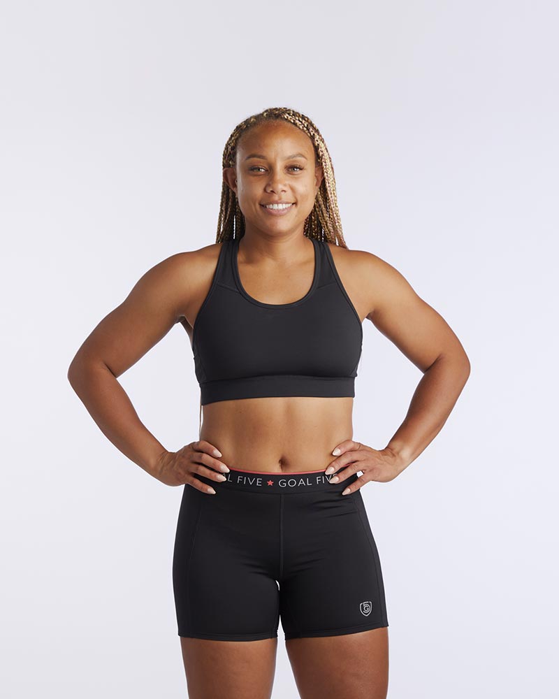 A woman wearing a 99er padded sports bra in black.