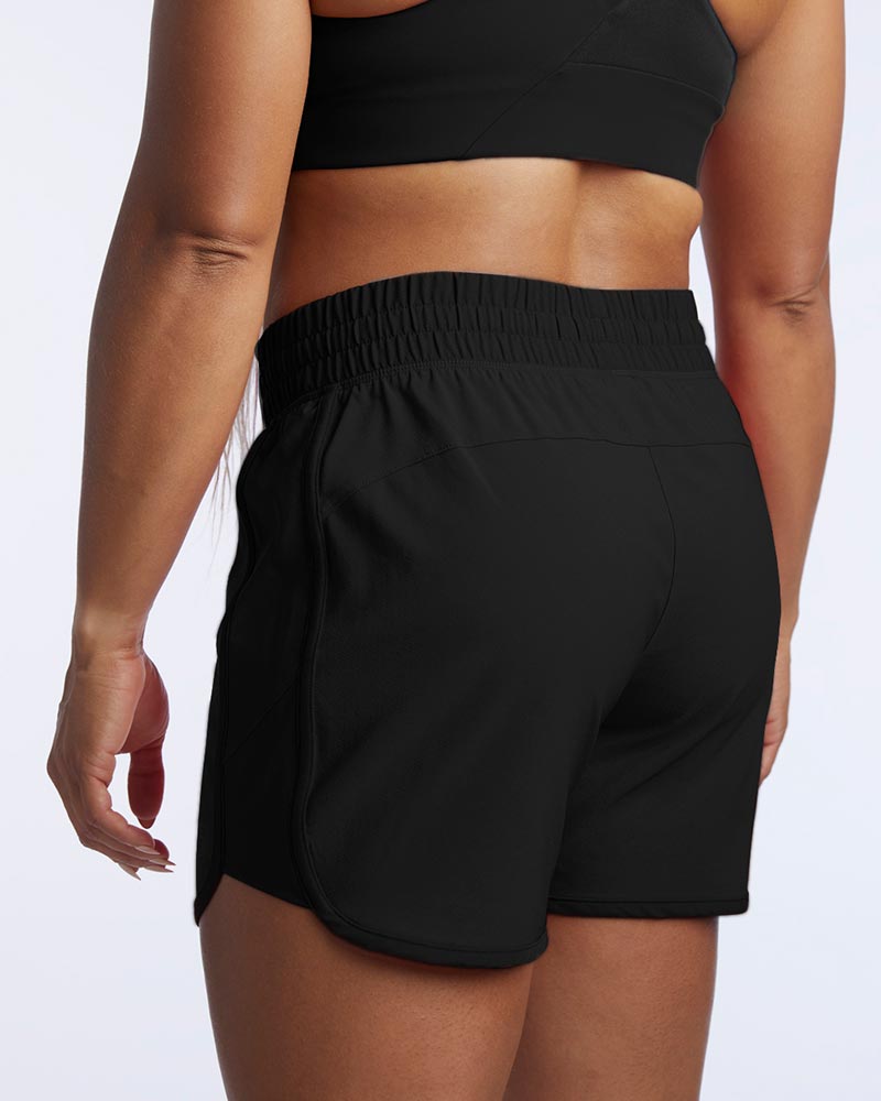 The model shows the back stitching of Indie women's sport shorts.