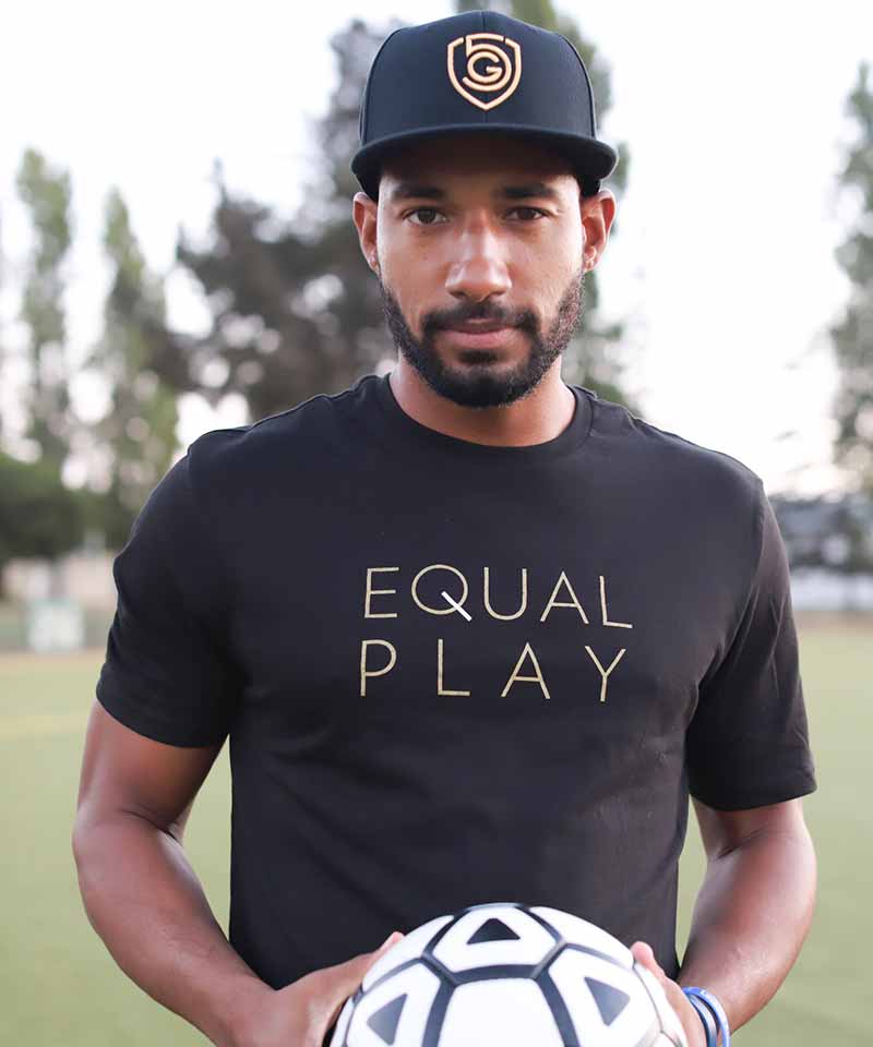 A male athlete wears the men's Equal Play T-Shirt on the field.